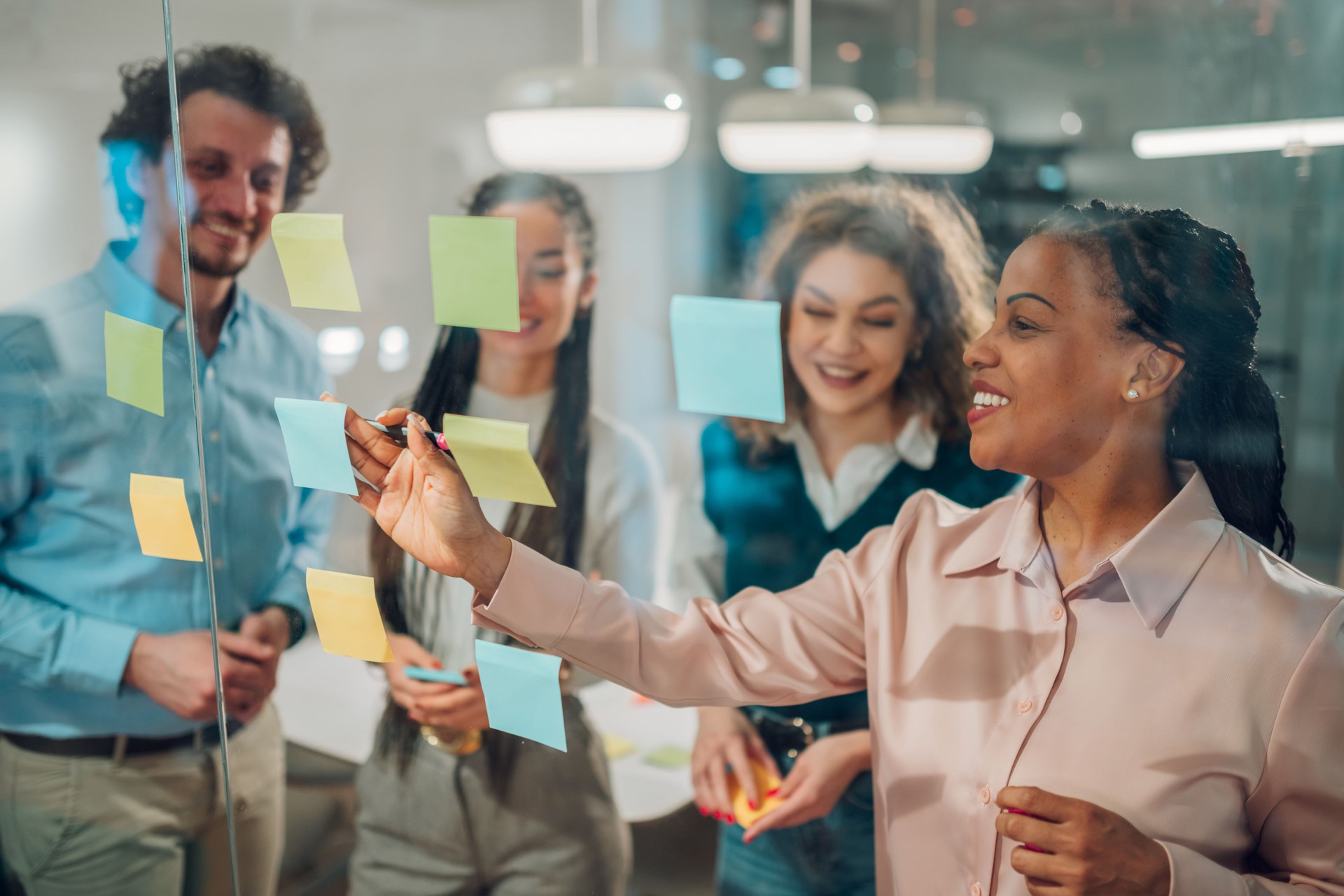 Businesswoman writing on sticky notes during a brainstorming session